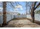 A fenced backyard with a concrete patio featuring a large tree at 2862 W Warren Ave, Denver, CO 80219