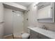 A full bathroom featuring a single sink vanity, toilet, and shower with built-in shelving at 2862 W Warren Ave, Denver, CO 80219