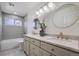 Bathroom featuring a double vanity, round mirrors, and combination bath and shower with tile surround at 22367 Quail Run Dr, Parker, CO 80138