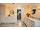 Spacious bathroom with dual vanities, stylish round mirrors with sconces, and a view to a walk-in closet at 22367 Quail Run Dr, Parker, CO 80138