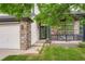 Charming front porch with stone accents, black railing, and beautiful landscaping at 22367 Quail Run Dr, Parker, CO 80138