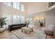 Open-concept living room showcases tall ceilings, modern furnishings, hardwood floors, and backyard views through large windows at 22367 Quail Run Dr, Parker, CO 80138