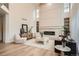 Elegant living room with a fireplace, modern decor, plush seating, and lots of natural light from the surrounding windows at 22367 Quail Run Dr, Parker, CO 80138