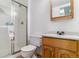 Compact bathroom featuring a glass shower, white toilet, and a wood vanity with sink at 2574 E Geddes Ave, Centennial, CO 80122