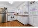 Well-lit kitchen featuring white cabinets, modern appliances, and hardwood flooring at 2574 E Geddes Ave, Centennial, CO 80122