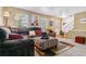 Comfortable living room with a plush sectional, patterned ottoman, and natural light from the windows at 2574 E Geddes Ave, Centennial, CO 80122