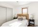 Bright bedroom with wood headboard, neutral bedding, and large windows at 4659 Wyandot St, Denver, CO 80211