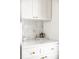 White kitchen cabinets with gold knobs and a marble backsplash at 4659 Wyandot St, Denver, CO 80211