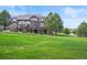 A view of the back exterior of the home with a large backyard at 8518 High Ridge, Castle Pines, CO 80108