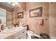 Well-lit bathroom featuring a clean white sink, framed mirror, and tiled shower at 8518 High Ridge, Castle Pines, CO 80108