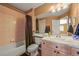 Bathroom featuring a single sink vanity and shower-tub combo at 8518 High Ridge, Castle Pines, CO 80108