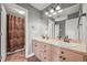 Bathroom showcasing a double sink vanity and shower-tub combo with updated fixtures at 8518 High Ridge, Castle Pines, CO 80108