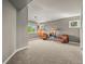 Spacious bonus room with comfortable seating, plush carpeting, and natural light from large windows at 8518 High Ridge, Castle Pines, CO 80108