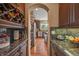 Butler's pantry featuring dark wood cabinets, granite counters, and wine rack at 8518 High Ridge, Castle Pines, CO 80108
