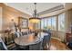 Elegant dining room featuring a unique chandelier, neutral color walls, and outside views at 8518 High Ridge, Castle Pines, CO 80108