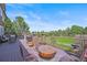 Spacious patio with an outdoor dining area, a fire pit, and views of a well-kept lawn at 8518 High Ridge, Castle Pines, CO 80108