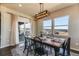 Bright dining room featuring an elegant light fixture and sliding glass doors to the deck with mountain views at 16088 Denver Pacific Dr, Monument, CO 80132