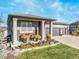 Beautiful home exterior with manicured lawn, flower beds, covered porch, and three-car garage at 16088 Denver Pacific Dr, Monument, CO 80132