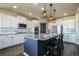Stylish kitchen featuring white cabinets, a black island, and stainless steel appliances at 16088 Denver Pacific Dr, Monument, CO 80132