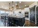 Bright kitchen with island seating, modern lighting, stainless appliances, and open dining area at 16088 Denver Pacific Dr, Monument, CO 80132