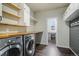 Convenient laundry room with washer, dryer, butcher block countertop, shelving, and hooks at 16088 Denver Pacific Dr, Monument, CO 80132