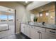 Bathroom featuring double sinks, granite countertops, a large mirror, and a connected bedroom at 16088 Denver Pacific Dr, Monument, CO 80132