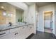 Main bathroom featuring double sinks, granite countertops, a walk-in shower, and a walk-in closet at 16088 Denver Pacific Dr, Monument, CO 80132