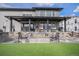 Backyard featuring an outdoor fire pit, covered porch with furniture, and artificial grass area at 3564 Doubletrack Ln, Castle Rock, CO 80108