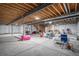 Unfinished basement featuring concrete floor, exposed ceiling with beams, and white plastic-covered walls at 3564 Doubletrack Ln, Castle Rock, CO 80108