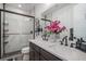 Renovated bathroom with double sinks, a quartz countertop, modern fixtures, and a shower with a glass enclosure at 3564 Doubletrack Ln, Castle Rock, CO 80108