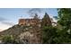 Scenic view of Castle Rock with lush trees and greenery in the foreground at 3564 Doubletrack Ln, Castle Rock, CO 80108