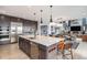 Open-concept kitchen with a large island, stainless steel appliances, and seamless flow into the living and dining areas at 3564 Doubletrack Ln, Castle Rock, CO 80108