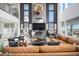 Cozy living room featuring a fireplace, leather sofa, high ceilings and abundant natural light at 3564 Doubletrack Ln, Castle Rock, CO 80108