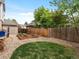 Landscaped backyard with a gravel area, garden beds, a wooden fence, and mature trees offering privacy and serenity at 1792 W Kettle Ave, Littleton, CO 80120