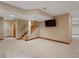Finished basement featuring neutral carpet, a staircase, and a wall-mounted TV, perfect for entertaining and relaxing at 1792 W Kettle Ave, Littleton, CO 80120