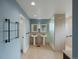 Bright bathroom featuring double pedestal sinks, framed mirrors, and a tiled shower with a glass partition at 1792 W Kettle Ave, Littleton, CO 80120