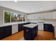 Well-lit kitchen features painted cabinets, a center island, and a large window overlooking the backyard at 1792 W Kettle Ave, Littleton, CO 80120