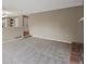 Spacious living room with neutral carpet and paint, adjacent to a dining area with a partial brick wall at 1792 W Kettle Ave, Littleton, CO 80120