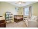 Cozy Bedroom featuring a crib, glider, and bookshelf filled with colorful books at 5007 S Richfield Cir, Aurora, CO 80015