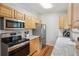 Bright kitchen with stainless steel appliances, granite countertops, and light wood cabinetry at 5007 S Richfield Cir, Aurora, CO 80015