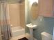 Classic bathroom with tub and shower combination, pedestal sink, and decorative mirror at 1441 Central St # 211, Denver, CO 80211