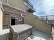 A patio with a hot tub, part of a brick building, under a blue, partly cloudy sky at 1441 Central St # 211, Denver, CO 80211