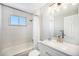 Bright white bathroom with tiled tub/shower, modern vanity, and a window at 155 S Pennsylvania St # 308, Denver, CO 80209