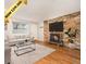 Inviting living room features a brick fireplace, hardwood floors, and a comfortable seating area with natural light at 155 S Pennsylvania St # 308, Denver, CO 80209