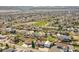 Aerial view of a home in a residential neighborhood with mature trees and mountain views at 8167 S Dover St, Littleton, CO 80128