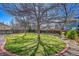 Landscaped backyard features a well-maintained lawn, mature trees, and a decorative brick border at 8167 S Dover St, Littleton, CO 80128