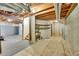 Unfinished basement with carpet, concrete, exposed ductwork, shelving, and staircase at 8167 S Dover St, Littleton, CO 80128