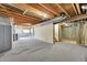 Unfinished basement features exposed beams, concrete walls, and carpeted flooring at 8167 S Dover St, Littleton, CO 80128