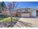 Two-story home showcasing the double door entryway, attached garage, and a spacious driveway at 8167 S Dover St, Littleton, CO 80128