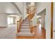 Bright foyer featuring a staircase, chandelier, and entryways to the living spaces at 8167 S Dover St, Littleton, CO 80128
